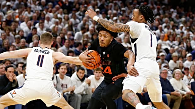 Miami (Fl) Hurricanes guard Nijel Pack (24) controls the ball as Virginia Cavaliers guard Dante Harris (1) and Cavaliers guard Isaac McKneely (11) defend